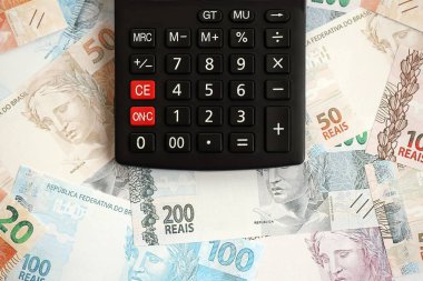 Brezilya banknotları ve hesap makinesi. Mevcut Brezilya gerçek para ve hesap makinesi büyük miktarda masada yatıyor. Brezilya 'da vergilendirme ve para konsepti