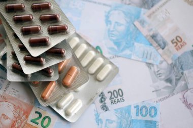 Brezilya bankaları ve ilaç hapları. Mevcut Brezilya gerçek para ve uyuşturucu banknotları büyük miktarda masada yatıyor. Brezilya 'da ilaç ve eczane kavramı