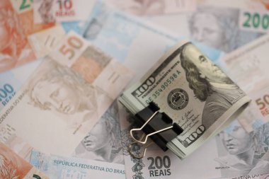 Bir sürü Amerikan doları büyük miktarda Brezilya banknotunun üzerinde yatar. Amerika 'nın parası Brezilya' nın para akışına bağlı. Brezilya 'da ekonomi ve döviz kuru kavramı