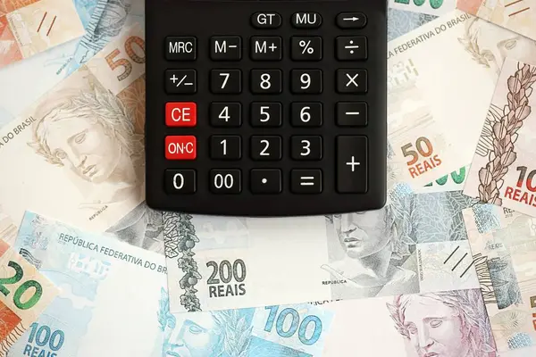 Brezilya banknotları ve hesap makinesi. Mevcut Brezilya gerçek para ve hesap makinesi büyük miktarda masada yatıyor. Brezilya 'da vergilendirme ve para konsepti
