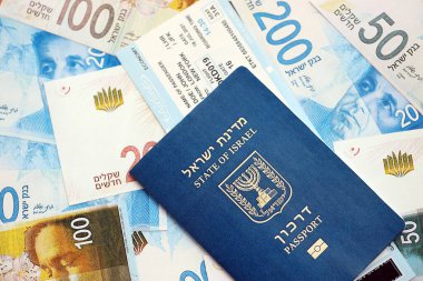 Israel New Shekels banknotları ve pasaportu. İsrail 'in mevcut para faturaları ve biyometrik geçiş kartı büyük miktarda masada yatıyor. İsrail 'de seyahat ve tatil kavramı