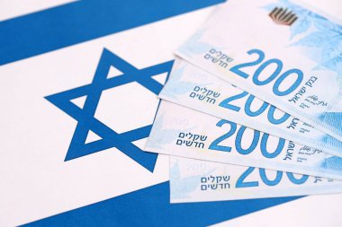 Israel New Shekels banknotları ulusal bayrak üzerinde. İsrail 'in şu anki para faturaları büyük oranda bayrağın üzerinde yatıyor. İsrail 'de iş ve yatırım kavramı