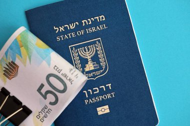 Israel New Shekels banknotları ve mavi arka planda pasaport. İsrail 'in şu anki para banknotları büyük oranda mavi üzerine yatar. İsrail 'de finans ve nakit kavramı