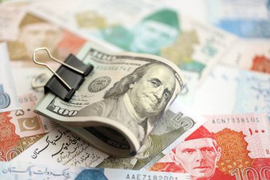 Amerikan dolarlarının rulosu Pakistan 'daki büyük miktardaki banknotların üzerinde yatıyor. Amerikan para demeti Pakistan 'ın para banknotlarında yatıyor. Pakistan 'da ekonomi ve döviz kuru kavramı