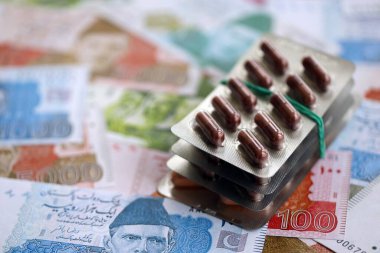 Pakistan banknotları ve ilaç hapları. Pakistan 'ın mevcut para ve uyuşturucu faturaları büyük miktarda masada yatıyor. Pakistan 'da ilaç ve eczane kavramı