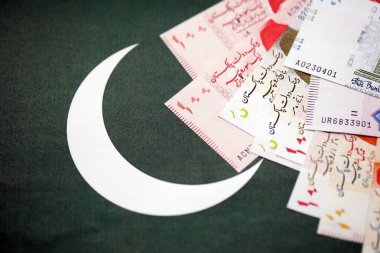 Pakistan 'ın bayrak geçmişi üzerine Pakistan banknotları. Pakistan 'ın mevcut para faturaları büyük miktarlarda pankartta yatıyor. Pakistan 'da ekonomi ve ticaret kavramı