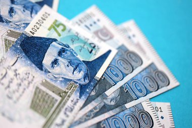 Pakistan banknotları mavi arka planda. Pakistan 'ın mevcut para faturaları büyük miktarda masada yatıyor. Pakistan 'da iş ve yatırım kavramı