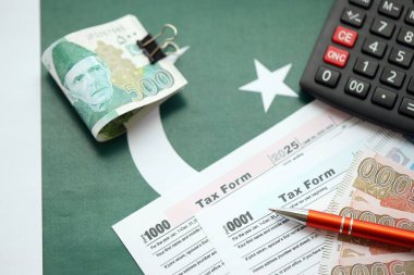 Pakistan hesap makinesi ve vergi formuyla banknotlar halinde. Şu anki Pakistan gerçek para ve vergi faturaları yakın plan. Pakistan 'da vergi ödeme ve muhasebe kavramı
