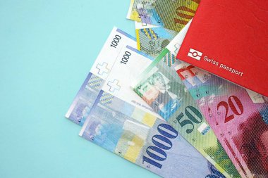 İsviçre frangı banknotları ve mavi üzerine pasaport. Mevcut para banknotları mavi üzerine kuruludur. İsviçre 'de iş ve yatırım kavramı