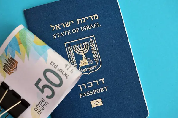 Israel New Shekels banknotları ve mavi arka planda pasaport. İsrail 'in şu anki para banknotları büyük oranda mavi üzerine yatar. İsrail 'de finans ve nakit kavramı