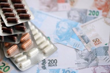 Brezilya bankaları ve ilaç hapları. Mevcut Brezilya gerçek para ve uyuşturucu banknotları büyük miktarda masada yatıyor. Brezilya 'da ilaç ve eczane kavramı