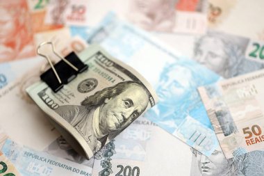 Bir sürü Amerikan doları büyük miktarda Brezilya banknotunun üzerinde yatar. Amerika 'nın parası Brezilya' nın para akışına bağlı. Brezilya 'da ekonomi ve döviz kuru kavramı