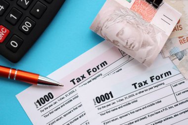 Brezilya banknotları, hesap makinesi ve vergi formlarıyla. Şu anki Brezilya gerçek para ve vergi borçları yakın plan. Brezilya 'da vergi ödeme ve muhasebe kavramı