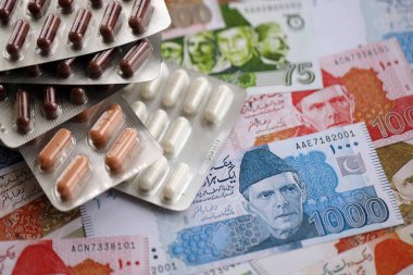 Pakistan banknotları ve ilaç hapları. Pakistan 'ın mevcut para ve uyuşturucu faturaları büyük miktarda masada yatıyor. Pakistan 'da ilaç ve eczane kavramı