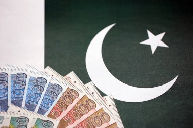 Pakistan 'ın bayrak geçmişi üzerine Pakistan banknotları. Pakistan 'ın mevcut para faturaları büyük miktarlarda pankartta yatıyor. Pakistan 'da ekonomi ve ticaret kavramı
