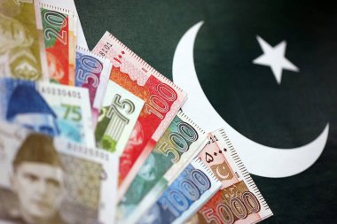 Pakistan 'ın bayrak geçmişi üzerine Pakistan banknotları. Pakistan 'ın mevcut para faturaları büyük miktarlarda pankartta yatıyor. Pakistan 'da ekonomi ve ticaret kavramı