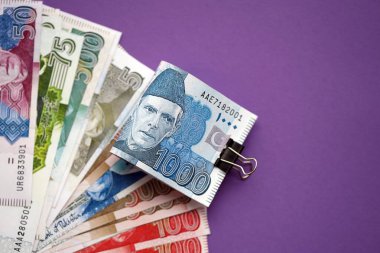 Pakistan mor arka planda banknotlar halinde. Pakistan 'ın mevcut para faturaları büyük miktarda masada yatıyor. Pakistan 'da iş ve yatırım kavramı