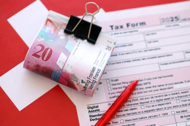 İsviçre frangı banknotları ve dolma kalemli vergi formu. Mevcut para faturaları vergi iade formunda yatıyor. İsviçre 'de vergilendirme kavramı