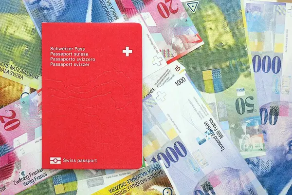 İsviçre frangı banknotları ve pasaportu. Mevcut banknotlar ve biyometrik geçiş kartları büyük miktarda masada yatıyor. İsviçre 'de seyahat ve tatil kavramı