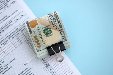 Masada 1040 bireysel gelir vergisi iadesi formuyla birlikte büyük miktarda Amerikan dolarları var. ABD 'de vergilendirme ve muhasebe kavramı