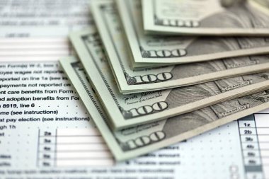 Masada 1040 bireysel gelir vergisi iadesi formuyla birlikte büyük miktarda Amerikan doları banknotları var. ABD 'de vergilendirme ve muhasebe kavramı