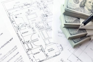 Kalemle birlikte yüklü miktarda Amerikan doları banknotları ve konut projesinin planları yakın plan. Yatırım ve inşaat projesi kavramı