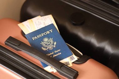 Biletlerle birlikte Amerika Birleşik Devletleri pasaportu havaalanının bekleme salonunda duran turistik bavulun üzerinde yatıyor. Dünya çapında seyahat ve uluslararası turizm kavramı