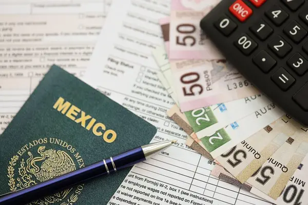 Meksika pezosu para faturaları kalem, hesap makinesi, pasaport ve vergi formlarıyla dolu. Finans ve bankacılık kavramı