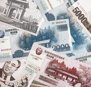 Kuzey Kore büyük miktarlarda para kazandı. Beyaz renkli masada yatıyor. Yakın plan. Finans ve bankacılık kavramı