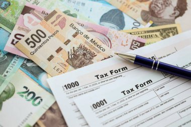 Değişik para birimlerinden ve ülkelerden oluşan büyük miktarlarda para ve vergi beyannamesi doldurulmaya hazır. Uluslararası nakitin çeşitli arka planında büyük bir yığın var.