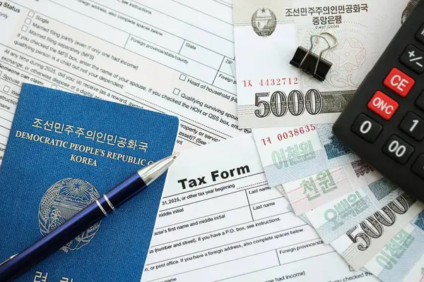 Kuzey Kore büyük miktarlarda para kazandı. Masada kalem, hesap makinesi, pasaport ve vergi formları var. Vergi ödeme ve muhasebe kavramı