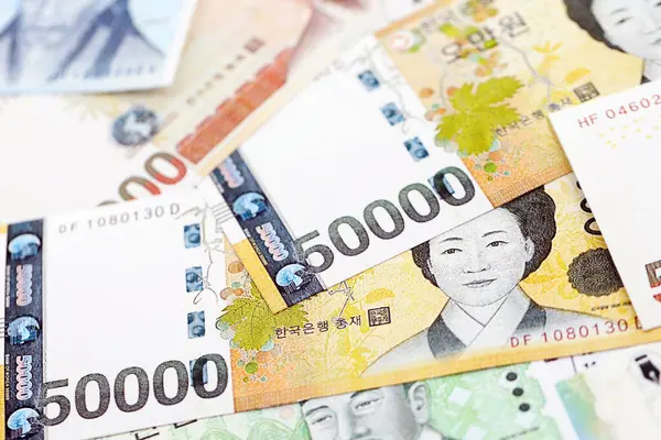 Güney Kore büyük miktarlarda para kazandı. Beyaz renkli masada yatıyor. Yakın plan. Finans ve bankacılık kavramı