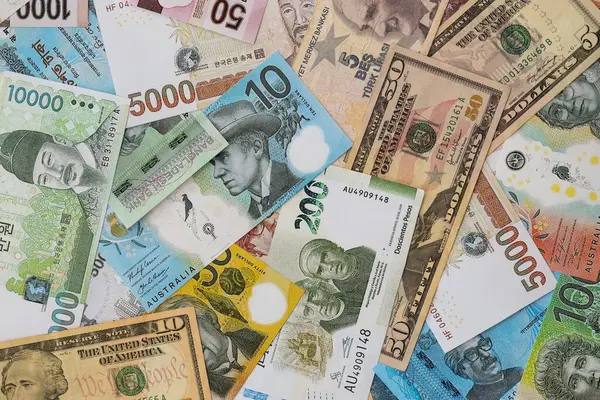 Farklı para birimlerinden ve ülkelerden yüklü miktarda para. Uluslararası nakitin çeşitli arka planında büyük bir yığın var.