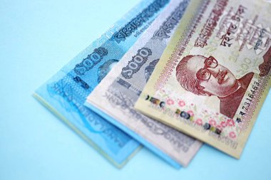 Bangladeşli para banknotları büyük miktarlarda deniz mavisi renkli masaların üzerinde. Finans ve bankacılık kavramı