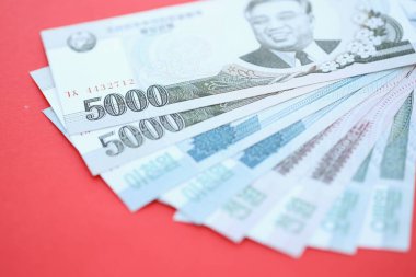 Kuzey Kore büyük miktarlarda para kazandı. Yakın plan kırmızı masada yatıyor. Finans ve bankacılık kavramı