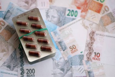 Brezilya bankaları ve ilaç hapları. Mevcut Brezilya gerçek para ve uyuşturucu banknotları büyük miktarda masada yatıyor. Brezilya 'da ilaç ve eczane kavramı