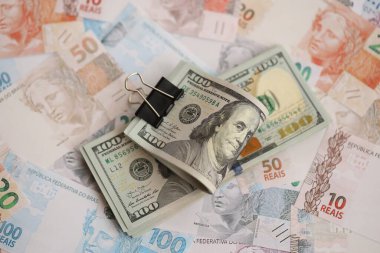 Bir sürü Amerikan doları büyük miktarda Brezilya banknotunun üzerinde yatar. Amerika 'nın parası Brezilya' nın para akışına bağlı. Brezilya 'da ekonomi ve döviz kuru kavramı