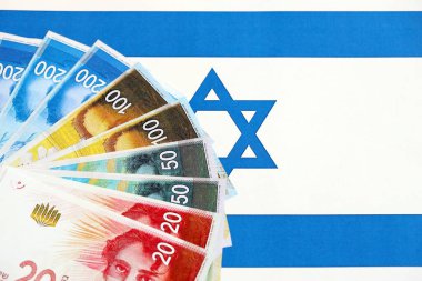 Israel New Shekels banknotları ulusal bayrak üzerinde. İsrail 'in şu anki para faturaları büyük oranda bayrağın üzerinde yatıyor. İsrail 'de iş ve yatırım kavramı