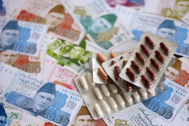 Pakistan banknotları ve ilaç hapları. Pakistan 'ın mevcut para ve uyuşturucu faturaları büyük miktarda masada yatıyor. Pakistan 'da ilaç ve eczane kavramı