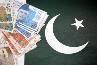 Pakistan 'ın bayrak geçmişi üzerine Pakistan banknotları. Pakistan 'ın mevcut para faturaları büyük miktarlarda pankartta yatıyor. Pakistan 'da ekonomi ve ticaret kavramı