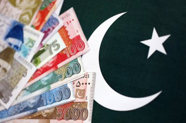 Pakistan 'ın bayrak geçmişi üzerine Pakistan banknotları. Pakistan 'ın mevcut para faturaları büyük miktarlarda pankartta yatıyor. Pakistan 'da ekonomi ve ticaret kavramı