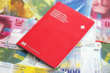 İsviçre frangı banknotları ve pasaportu. Mevcut banknotlar ve biyometrik geçiş kartları büyük miktarda masada yatıyor. İsviçre 'de seyahat ve tatil kavramı