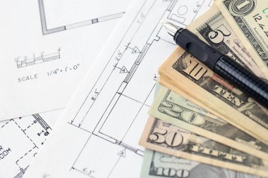 Kalemle birlikte yüklü miktarda Amerikan doları banknotları ve konut projesinin planları yakın plan. Yatırım ve inşaat projesi kavramı
