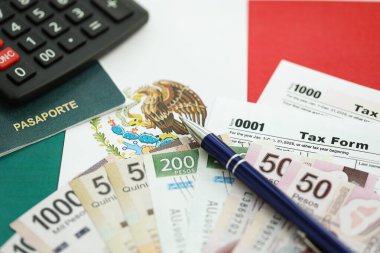 Meksika pezosu para faturaları kalem, hesap makinesi, pasaport ve vergi formlarıyla dolu. Finans ve bankacılık kavramı