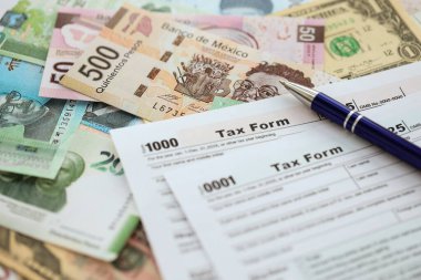 Değişik para birimlerinden ve ülkelerden oluşan büyük miktarlarda para ve vergi beyannamesi doldurulmaya hazır. Uluslararası nakitin çeşitli arka planında büyük bir yığın var.