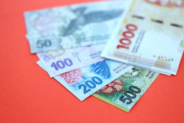 Arjantin pezosu büyük miktarlarda para kırmızı renkli masaya yakın duruyor. Finans ve bankacılık kavramı