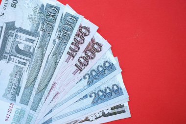 Kuzey Kore büyük miktarlarda para kazandı. Yakın plan kırmızı masada yatıyor. Finans ve bankacılık kavramı