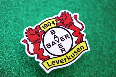 KYIV, UKRAINE - 23 Şubat 2025 Bayer 04 Leverkusen futbol kulübü rozeti zümrüt yeşili simli arka plan pankartıyla uzanır