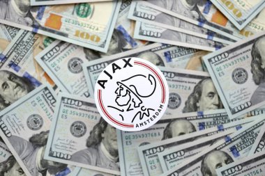 KYIV, UKRAINE - 23 Şubat 2025 AFC Ajax futbol kulübü rozeti büyük miktarlarda Amerikan doları üzerinde yatıyor
