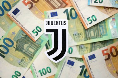 KYIV, UKRAINE - 23 Şubat 2025 Juventus FC futbol kulübü rozeti büyük miktarda EURO para banknotlarının üzerinde yatıyor